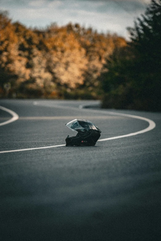 a motorcycle on a curved road near some trees