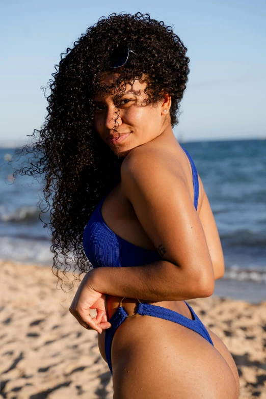 a young woman posing for the camera on a beach