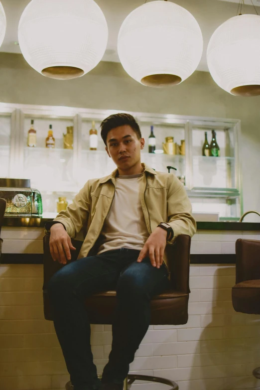 a man sitting in a bar next to a counter