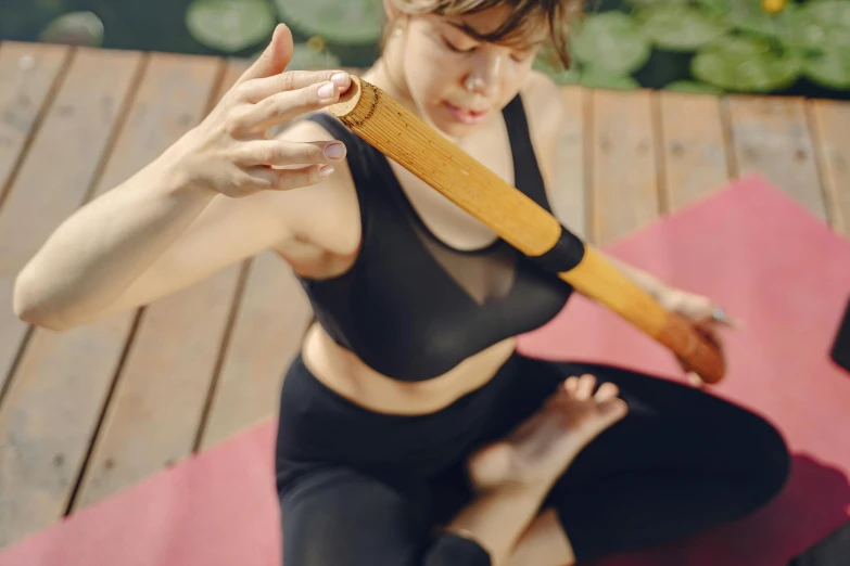 a person sitting on a mat with a bat in hand