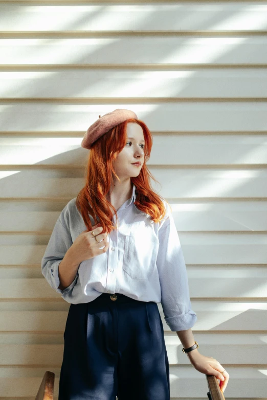 a girl is standing on the wall and smiling