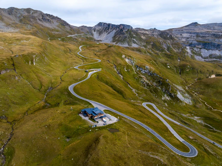 a road winding up into the mountains on a cloudy day