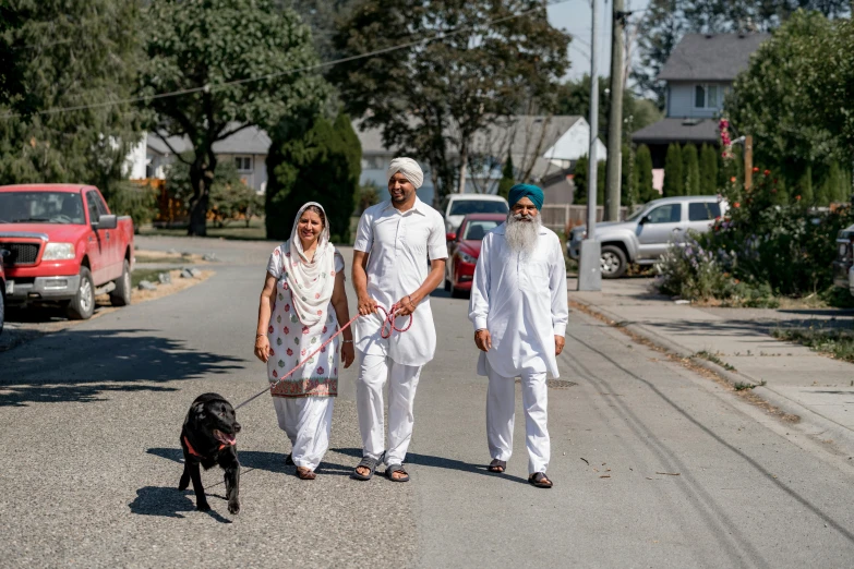 a group of people walking a dog down the street