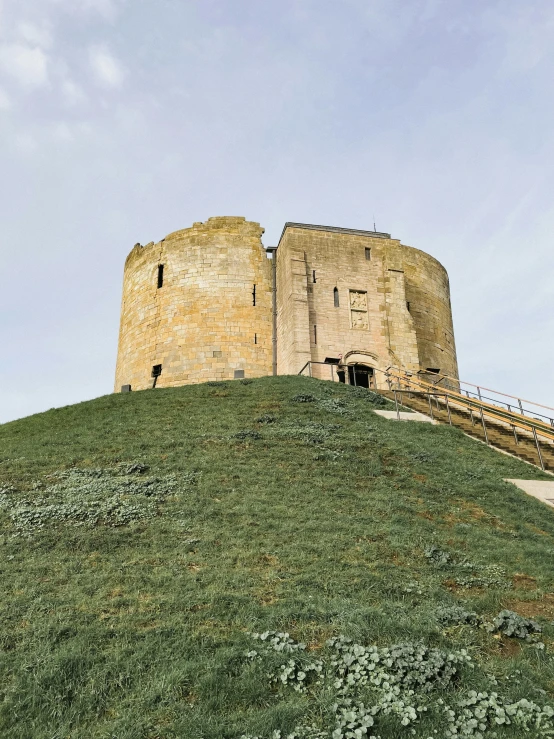 a couple of towers on top of a hill with grass