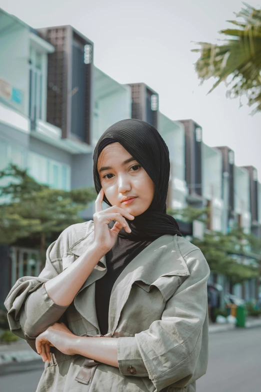 a woman in hijab on the phone and looking at camera