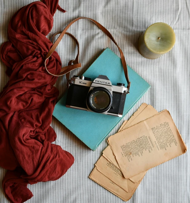 a table topped with a book, camera and other items