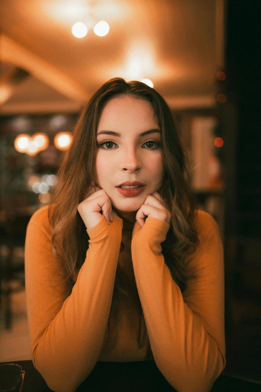 a woman posing for a picture with her hands on her cheeks