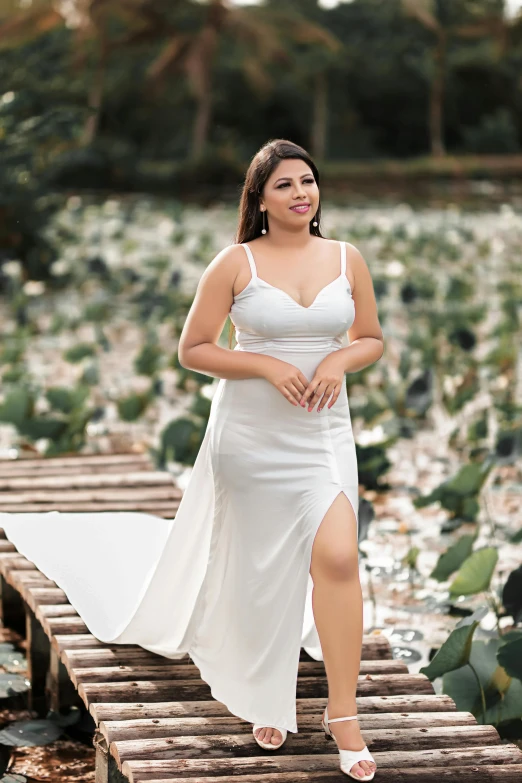 a plus sized woman in white clothing poses for a pograph