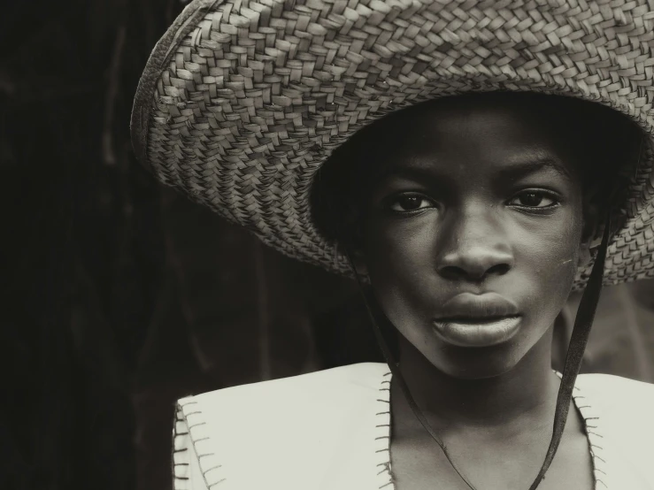 a black woman wearing a hat looking into the camera