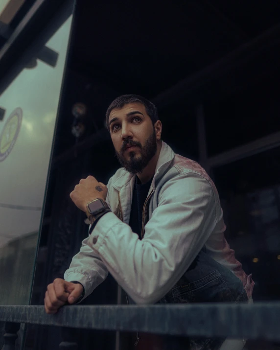 a man posing with his hands on the railing