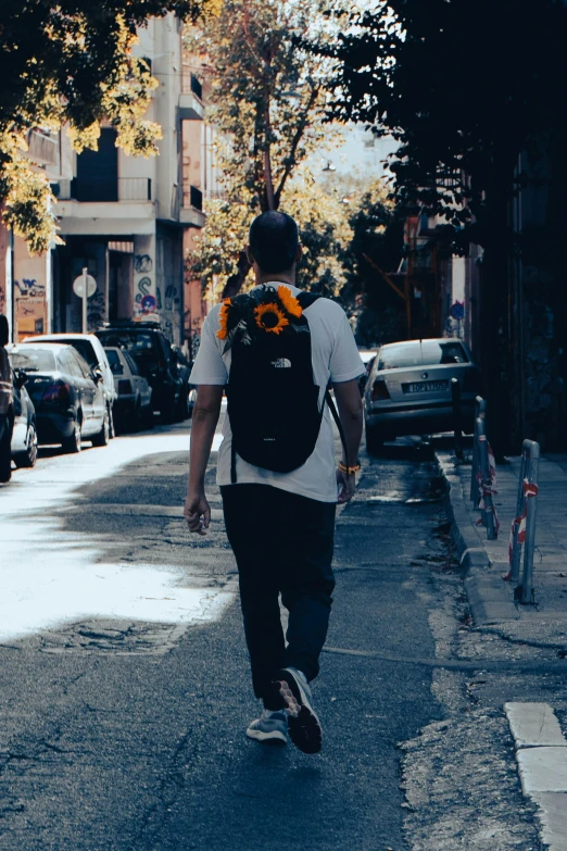 skateboarder with flower headband walking down an urban street