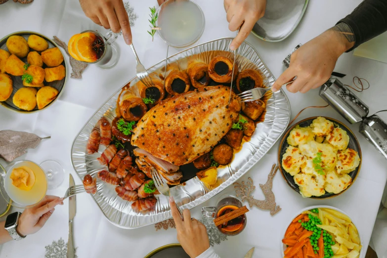 people sitting at a table sharing a turkey meal