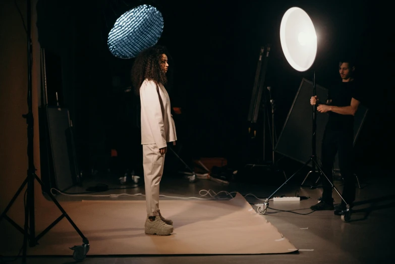 three actors standing near camera equipment, one directing and the other filming