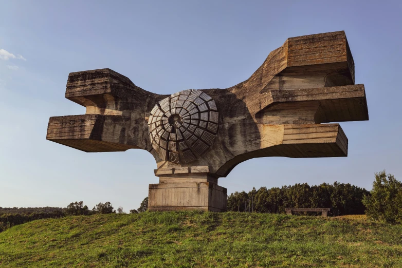 a sculpture depicting an abstract view on top of a grassy hill