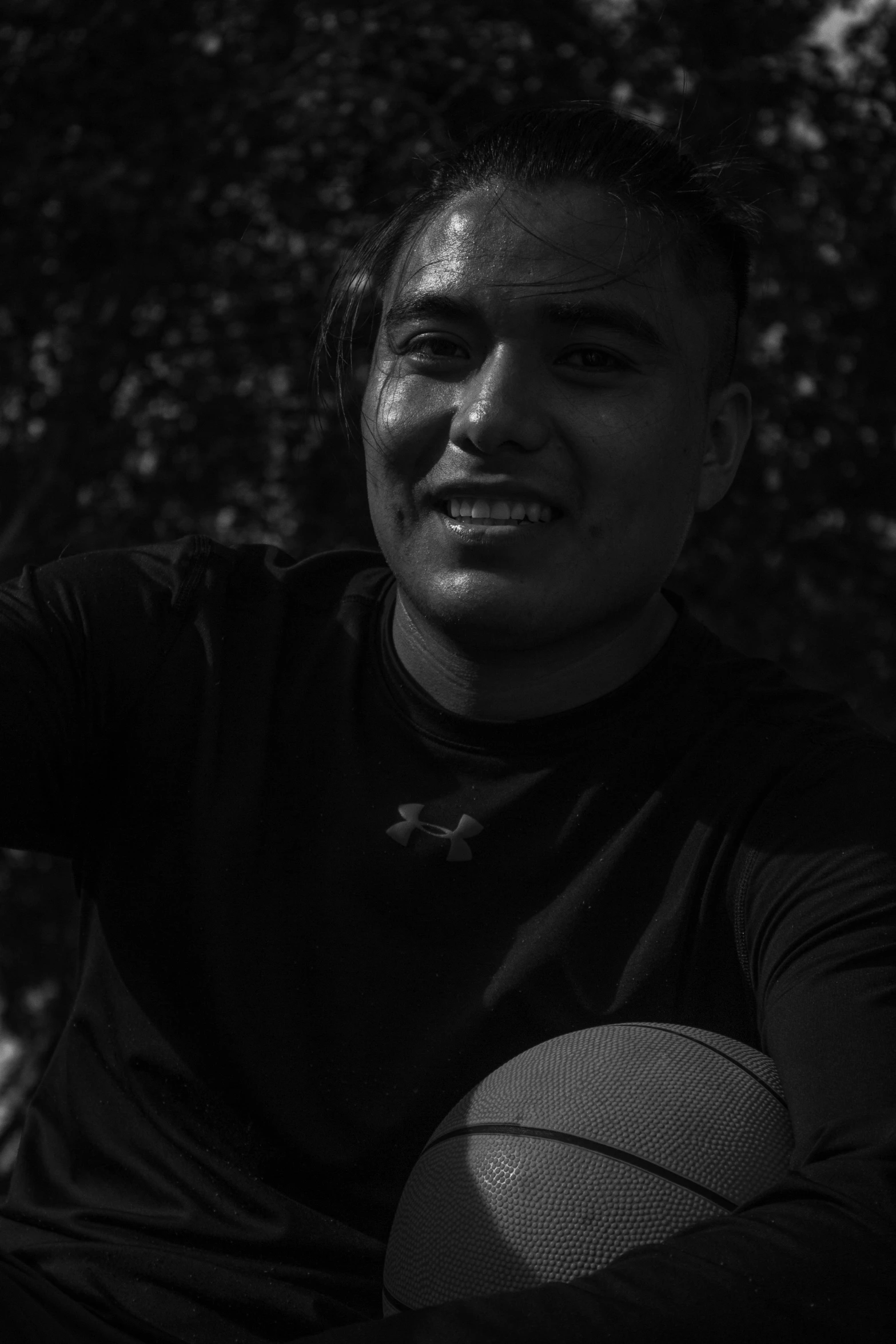 a young man holding a basketball on his left hand