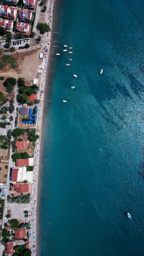 a wide beach lined with boats next to the ocean