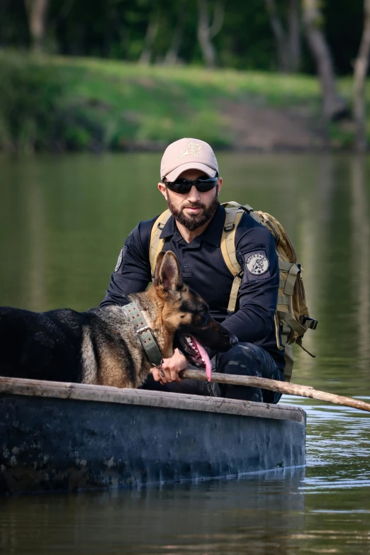 man sitting in the water with two dogs