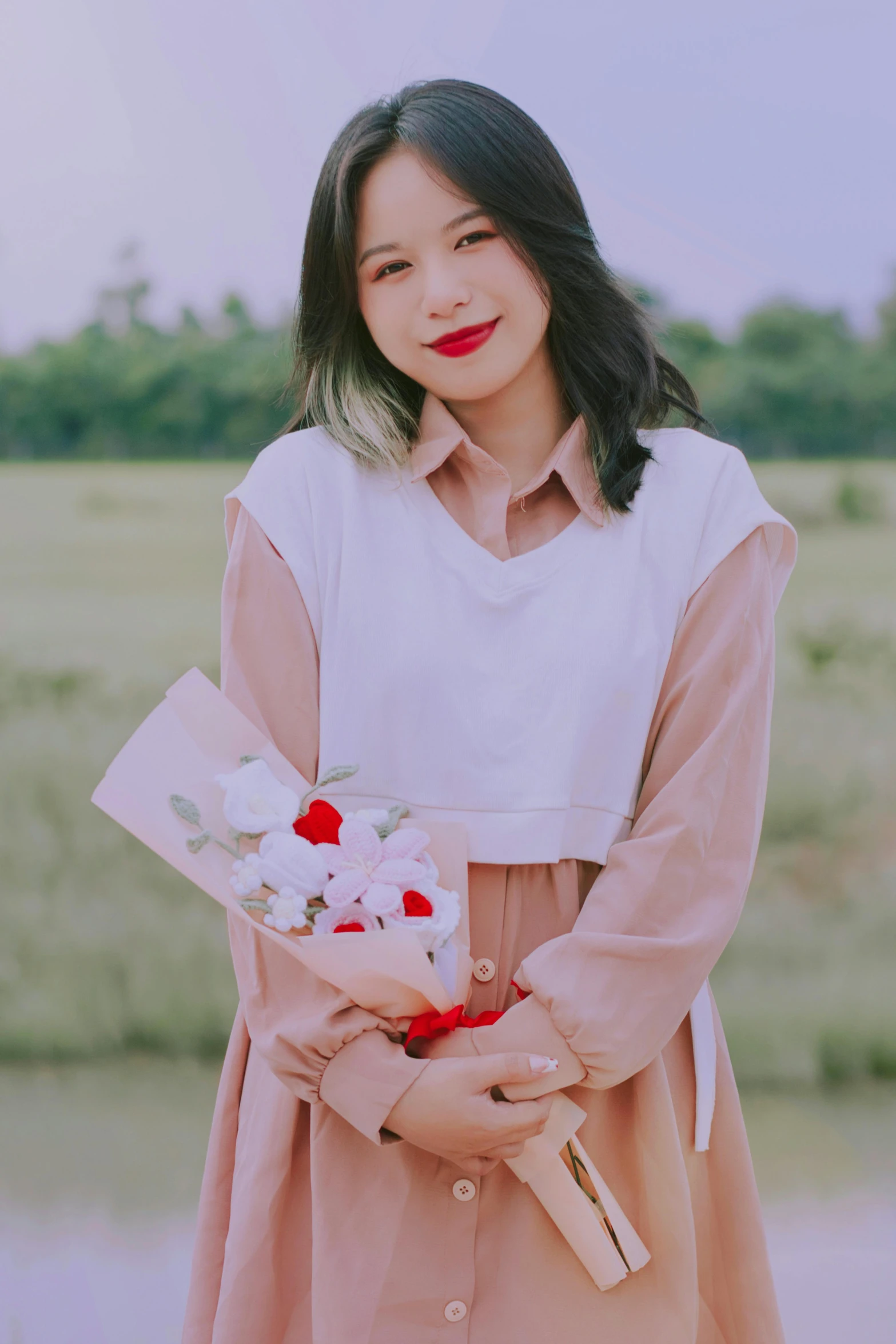 a young asian woman with long black hair holds flowers