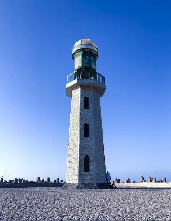 a light house standing in the sand near a beach