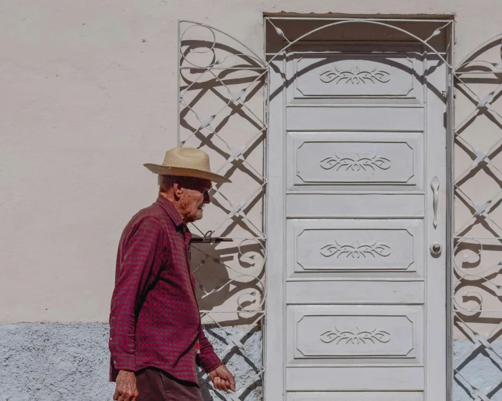 an older man walking past a wooden door