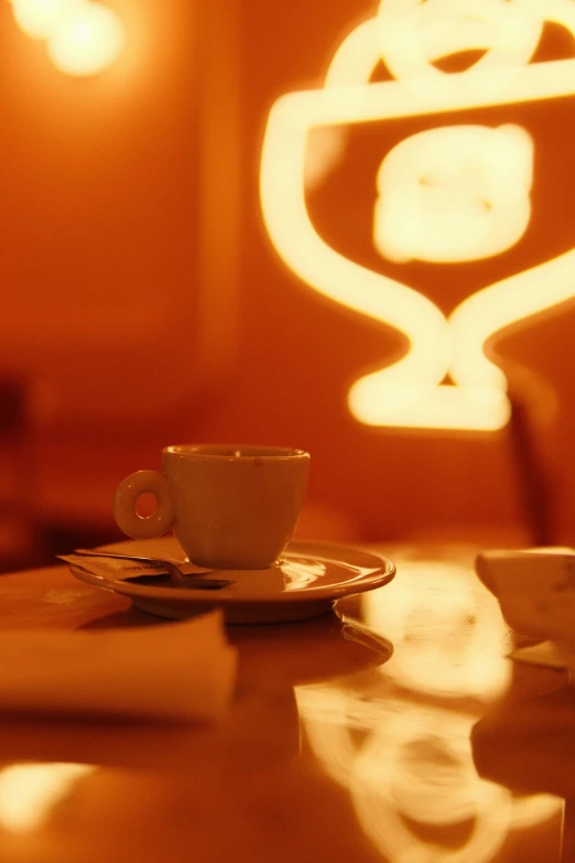 a table with a cup, saucer and a spoon on it