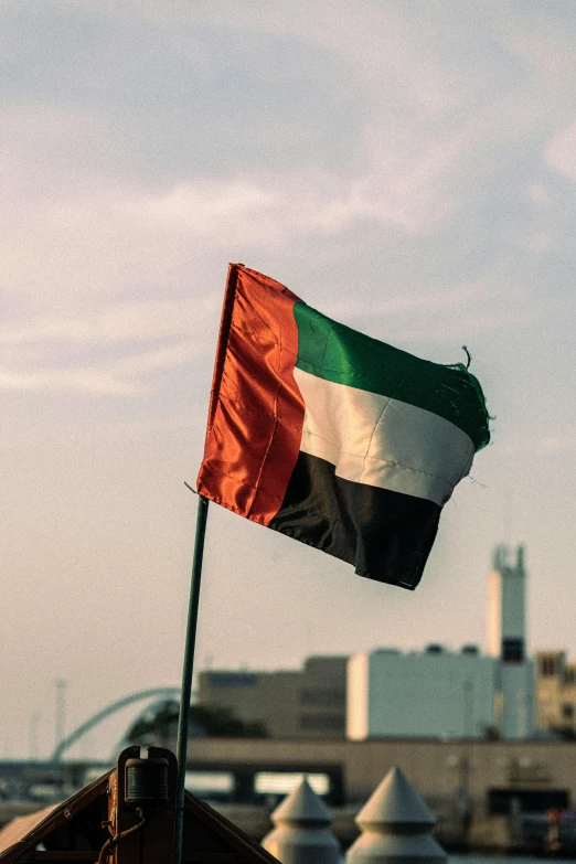 a green, white and black flag flying in the wind