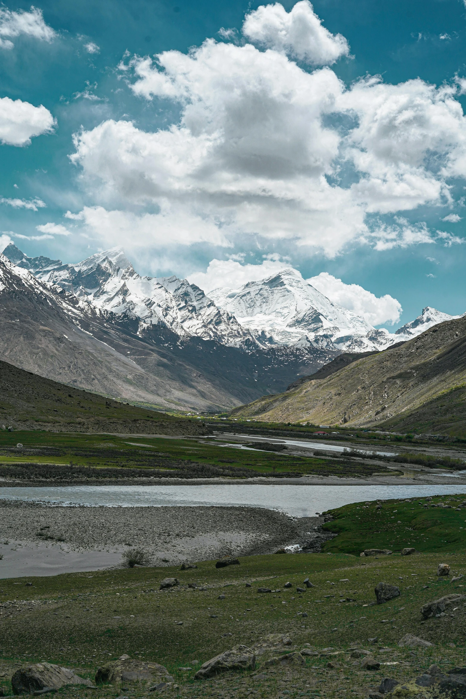 mountains and a body of water surrounded by a grassy field