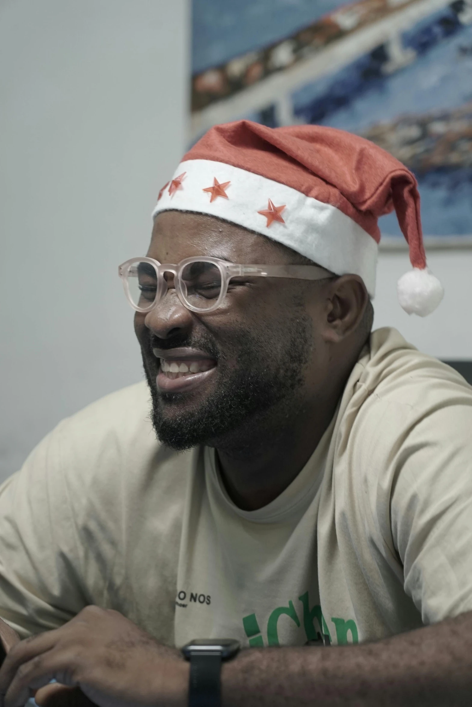 a man wearing a santa hat with glasses sits at a desk