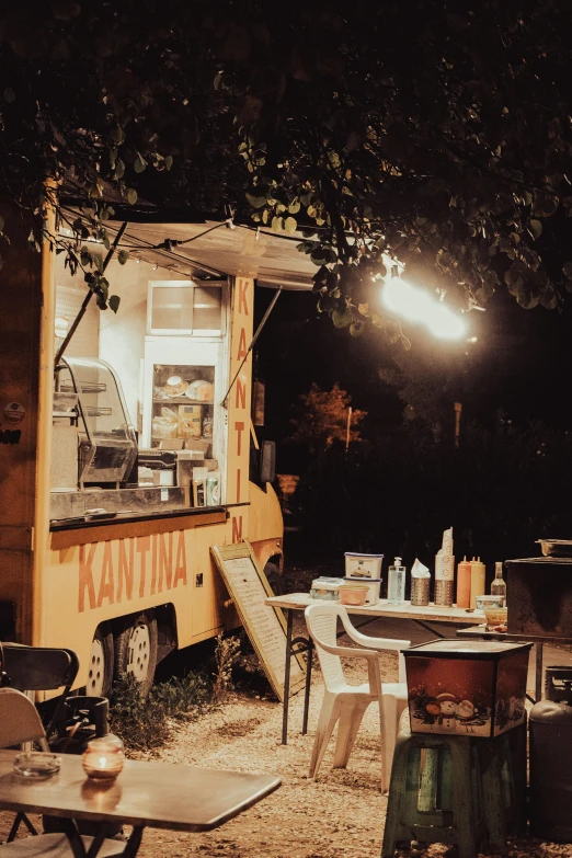 a food truck is parked in the dirt with tables