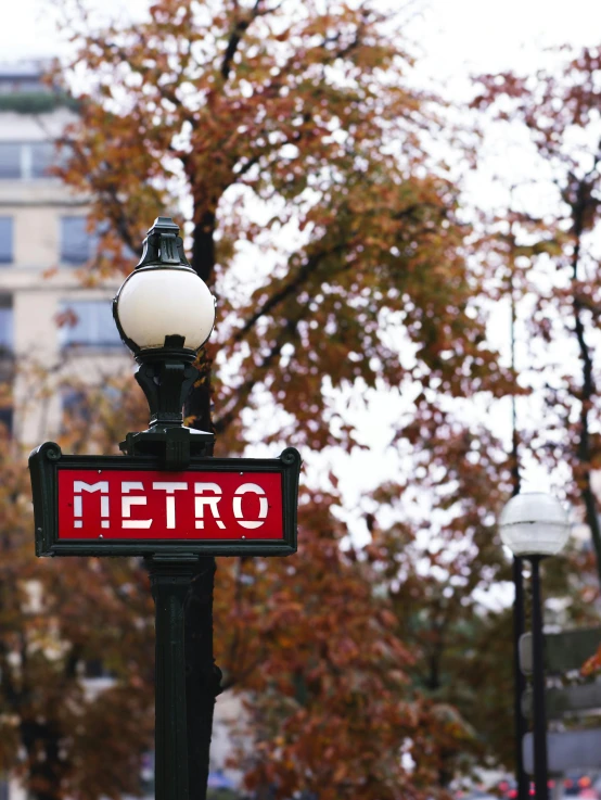 a metro sign is seen with other buildings in the background