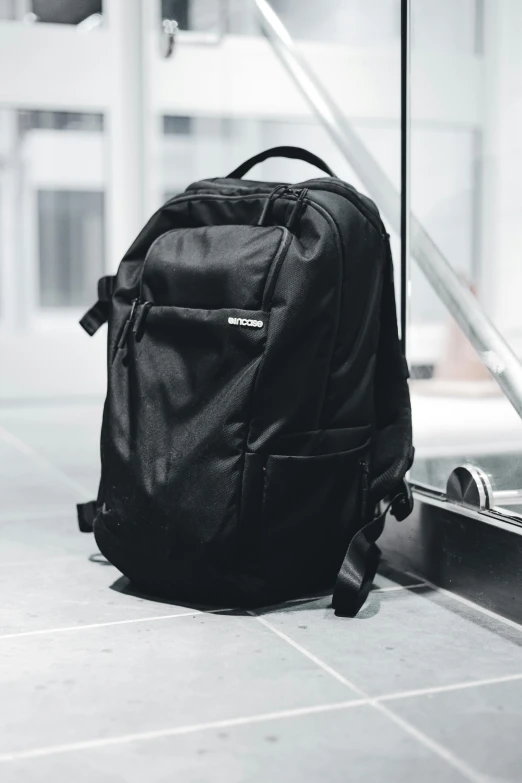 a small backpack sitting on the floor next to a railing