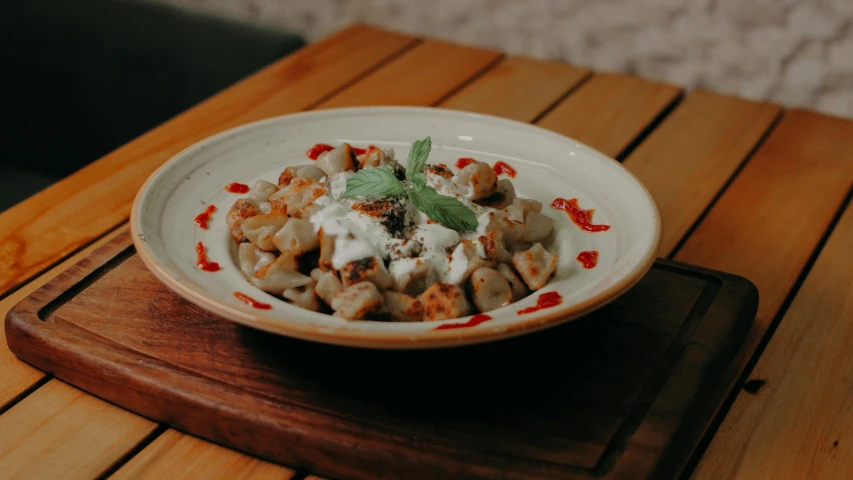 a dish is filled with meat and vegetables on top of a wooden board