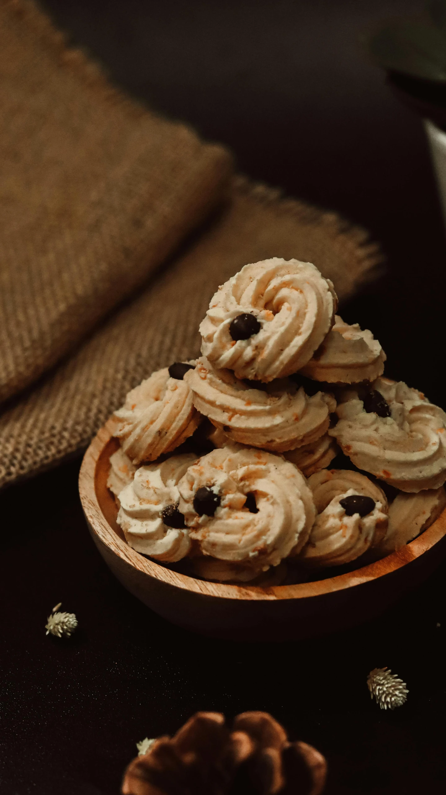 several small cookies with white frosting on a brown plate