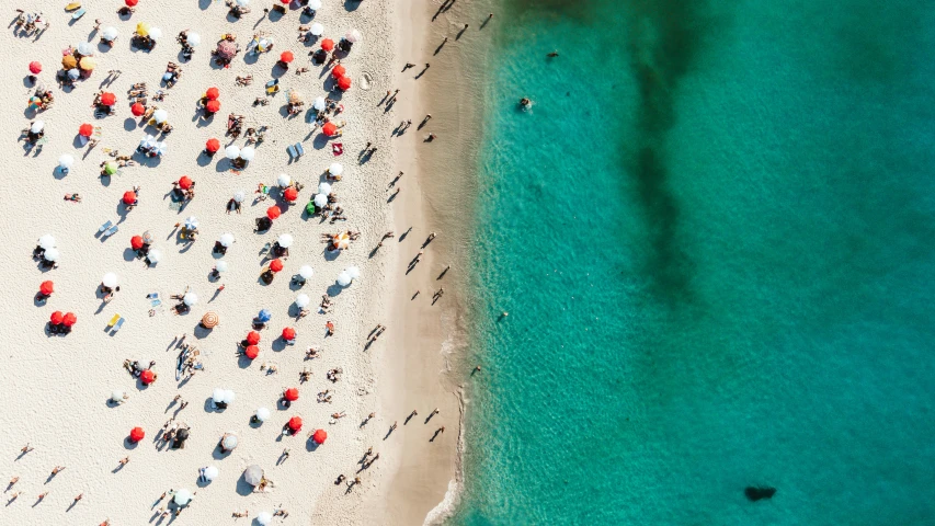 people on a beach with blue and green water