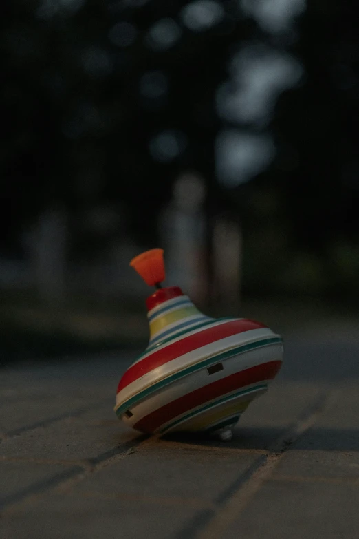 a colorful vase is on the ground in the dark