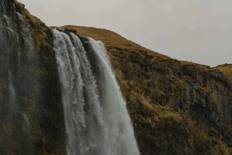 a waterfall flowing into a very tall body of water