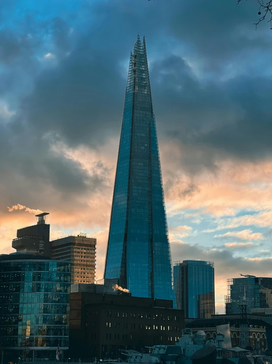 a tall building with many windows is against the cloudy sky