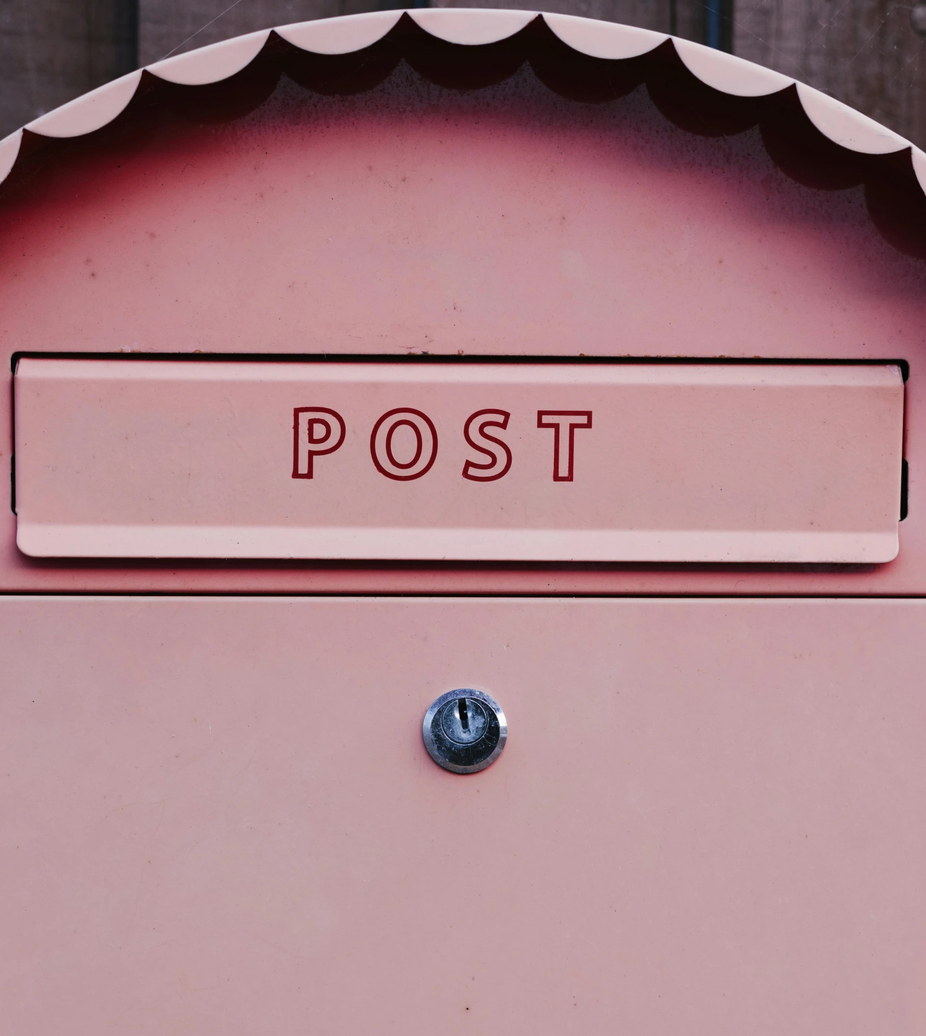 the top corner of a pink mailbox with the word post