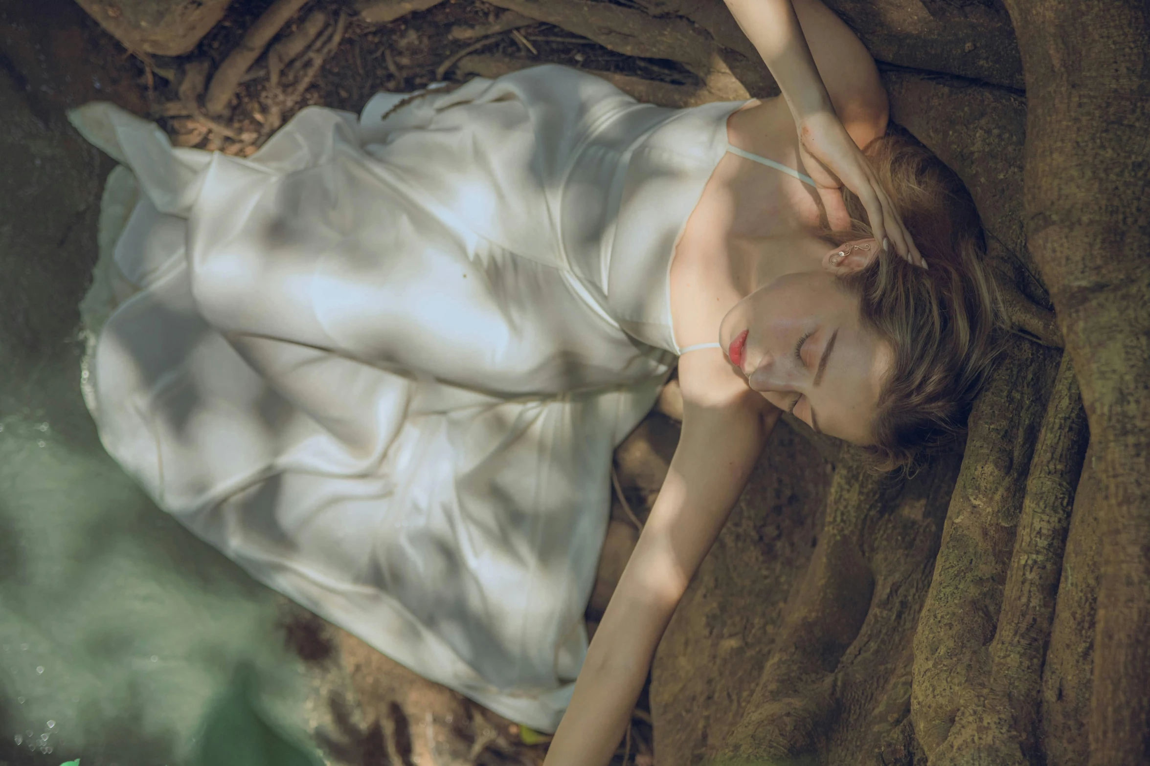 a girl in white dress laying on the ground