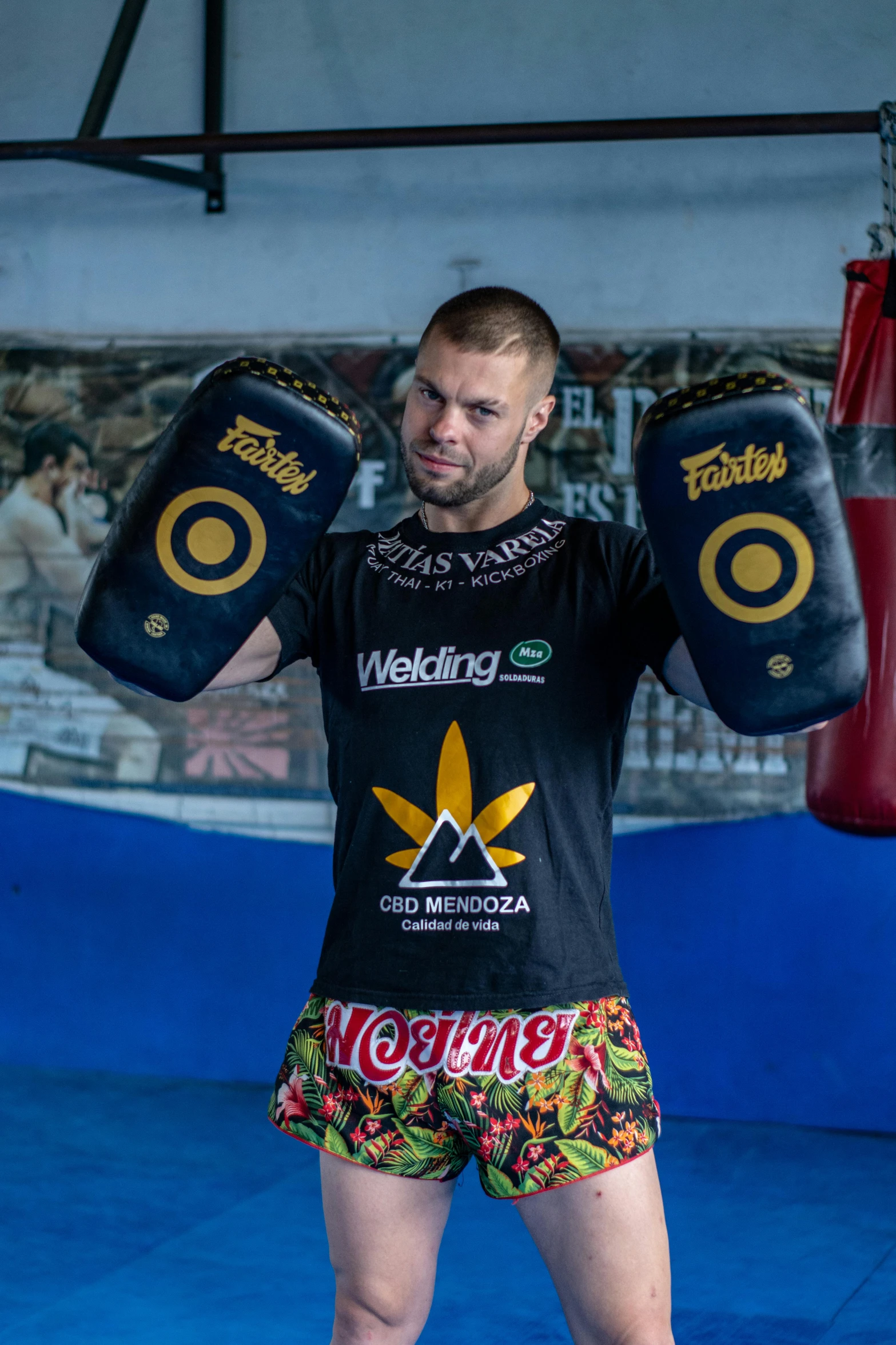 a man holding onto a punching glove in a gym