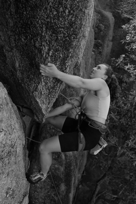 a person climbing up a steep hill with a rope