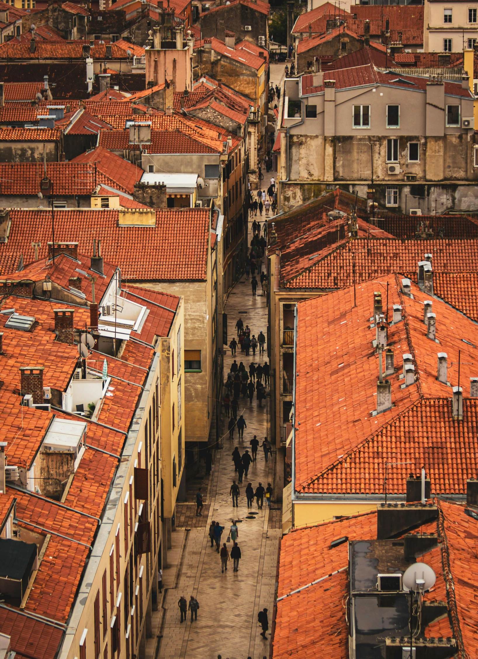 an aerial view of rooftops and people walking around