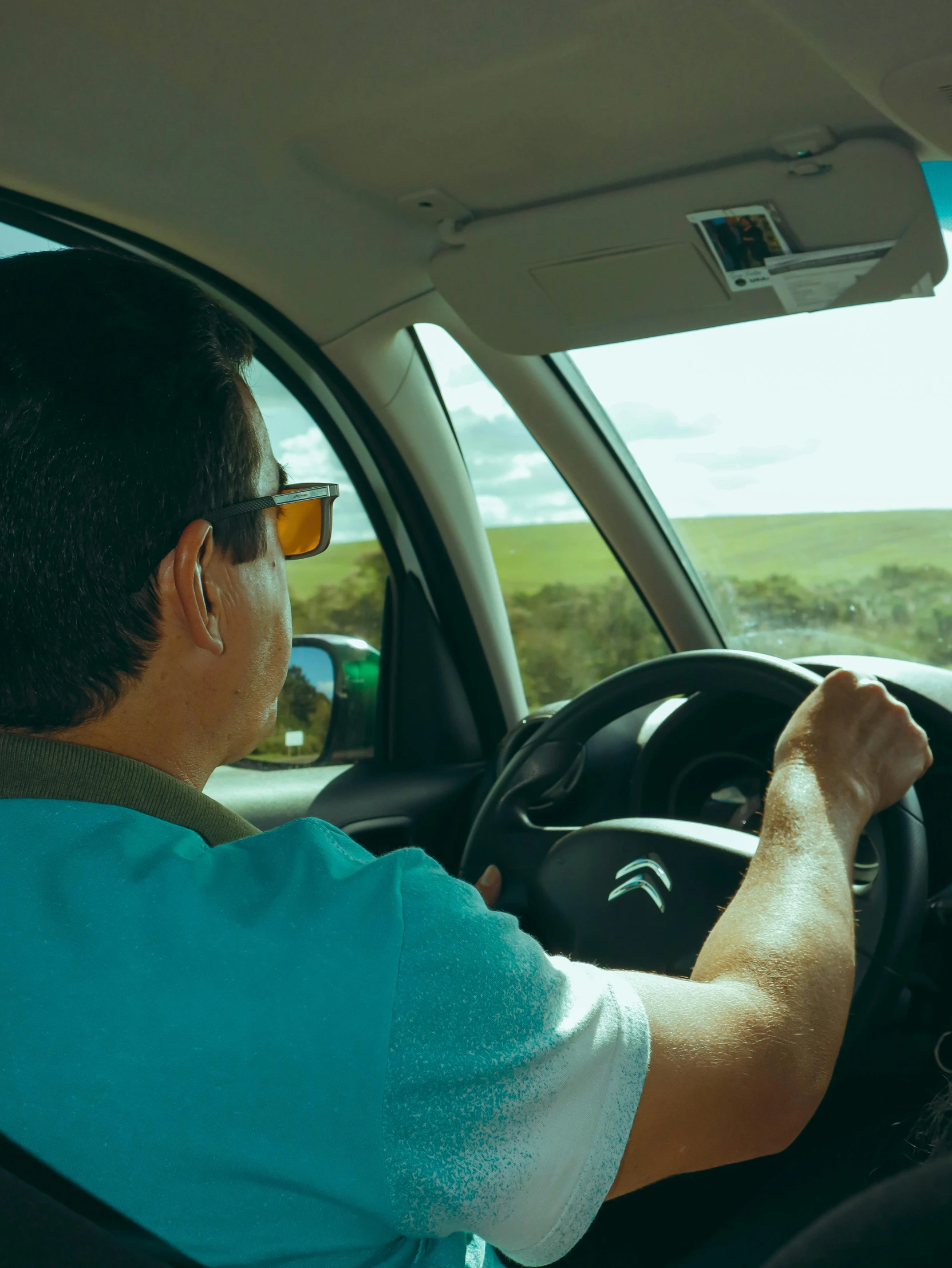 a man driving a car on a country road