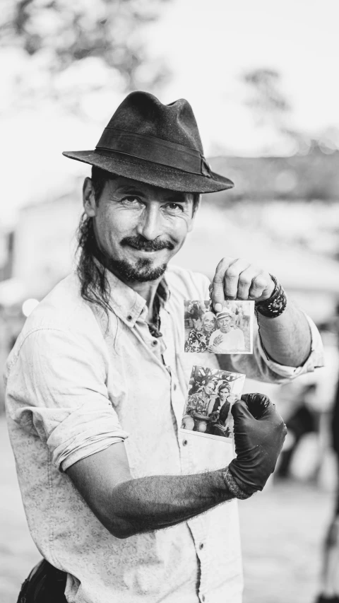 a man wearing a hat, tie and jeans standing outside