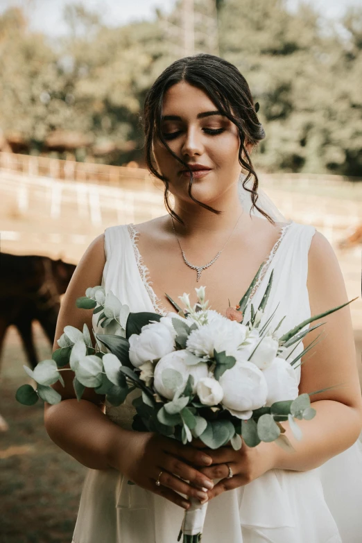 a bride holding a bouquet of white flowers