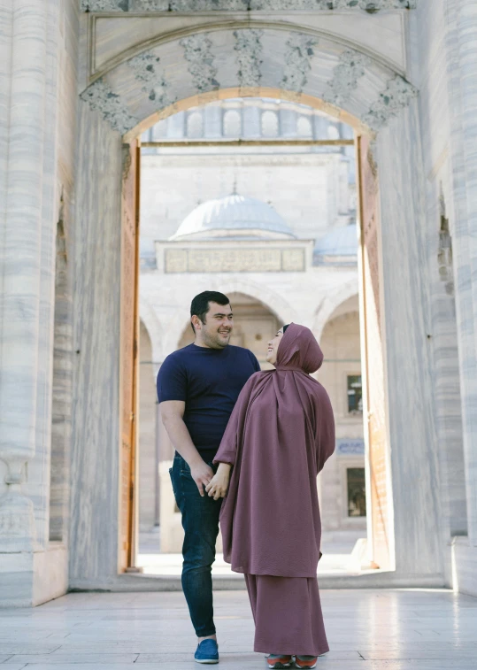 a couple standing in an archway facing each other