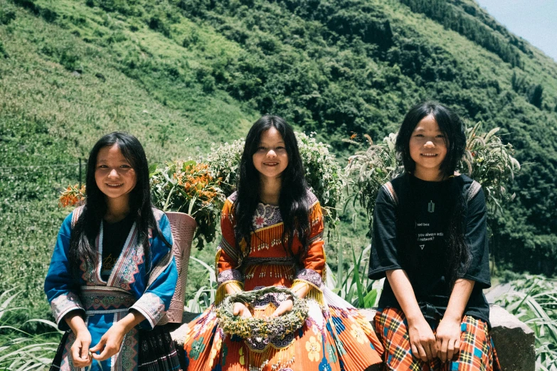 three woman in native clothing standing on a mountain
