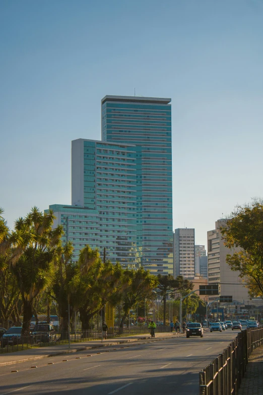 an empty city street with tall buildings and trees