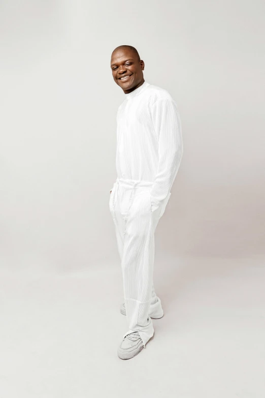 a man wearing white poses for a pograph