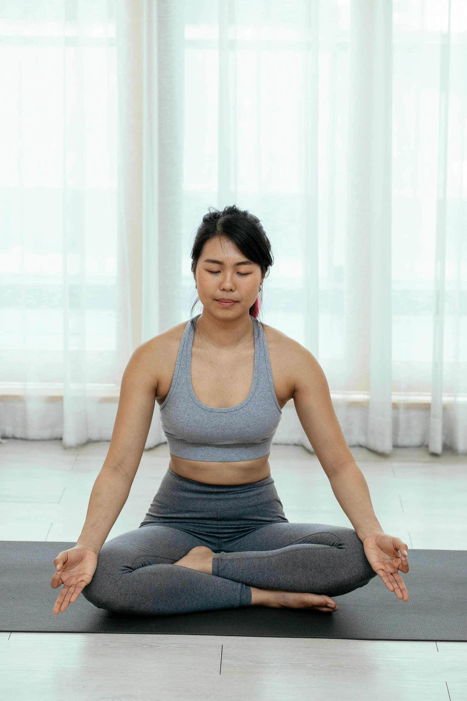 a women who is practicing yoga in the middle of a room